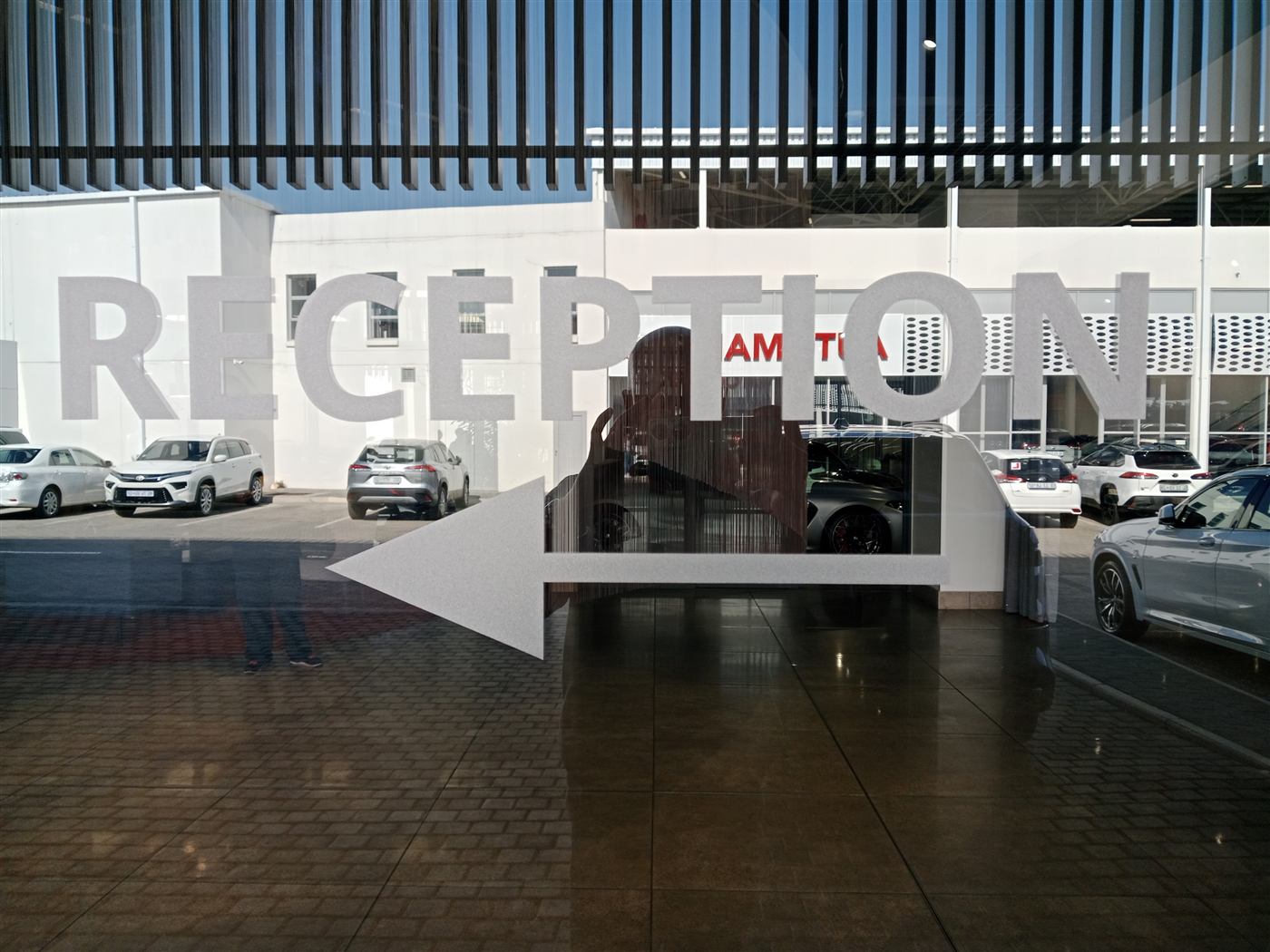 Reception directional arrow signage on glass, wide view